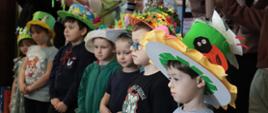 Uczniowie stoją w rzędzie na głowach mają własnoręcznie wykonane kapelusze