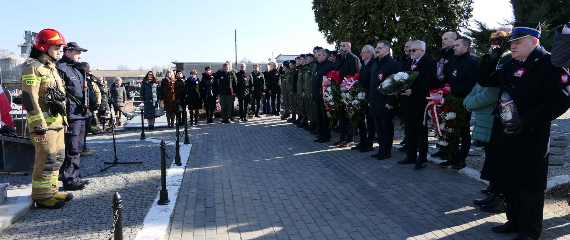 Uczestnicy uroczystości śpiewają Hymn Narodowy.