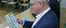 Starosta Hajnowski Andrzej Skiepko przegląda ulotkę z ofertą edukacyjną ZSZ