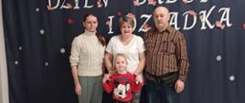 Przedszkolaki pozują do zdjęcia ze sowimi bliskimi, zaproszonymi na uroczystość
