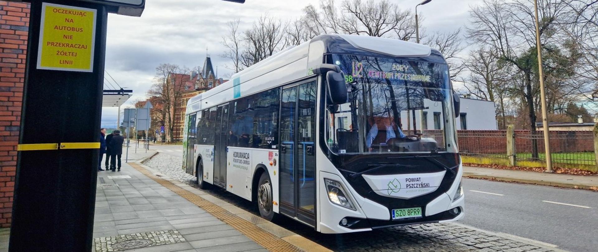 Biały autobus stoi na przystanku