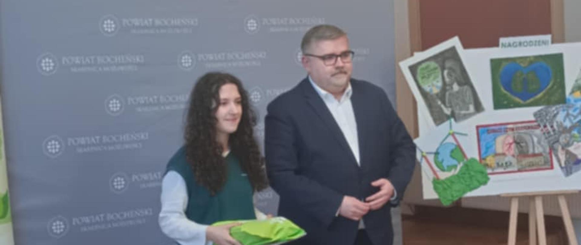 Uczennica pozuje do zdjęcia ze Starostą Bocheńskim w jednej z sal starostwa