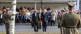 Dzień Pamięci Więźniów Obozu Dulag 121 i Niosących Im Pomoc. - fotorelacja - na zdjęciu moment składania wiązanek przez Przewodniczącego i Wiceprzewodniczącego Rady Powiatu Pruszkowskiego 