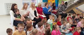 Uczestnicy konkursu wraz przedstawicielami Organizatora konkursu, dyrekcją i nauczycielkami z przedszkola siedzą w sali zabaw
