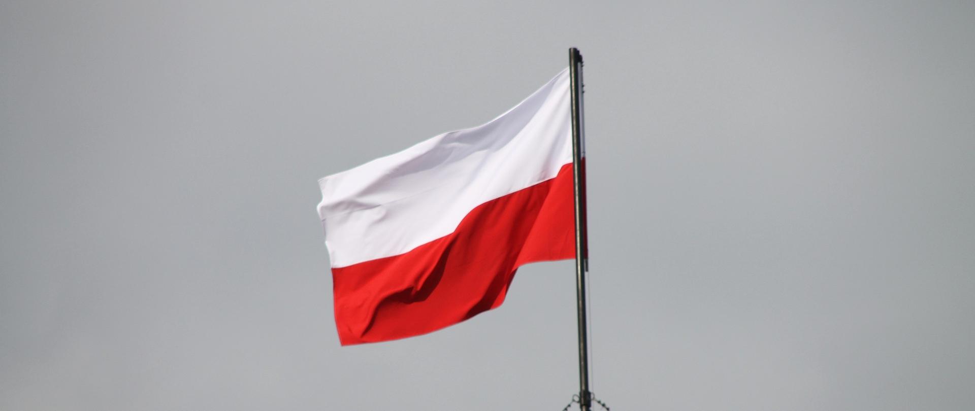 Na zdjęciu flaga Polski powiewająca na maszcie.
