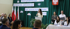 na zdjęciu znajduje się starosta zambrowski, która przemawia przez mikrofon do zgromadzonych gości i społeczności szkolnej ZSA