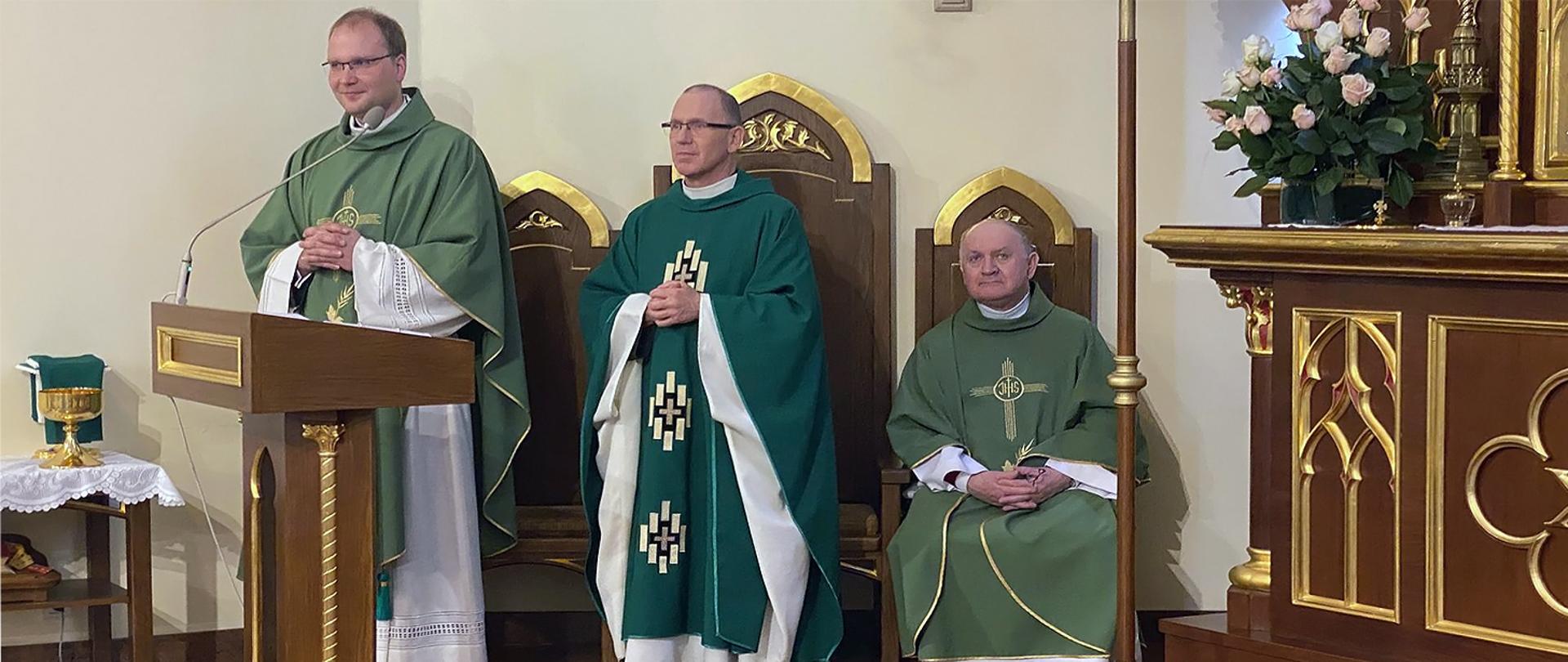 Trzej księża przy ołtarzu w zielonych ornatach