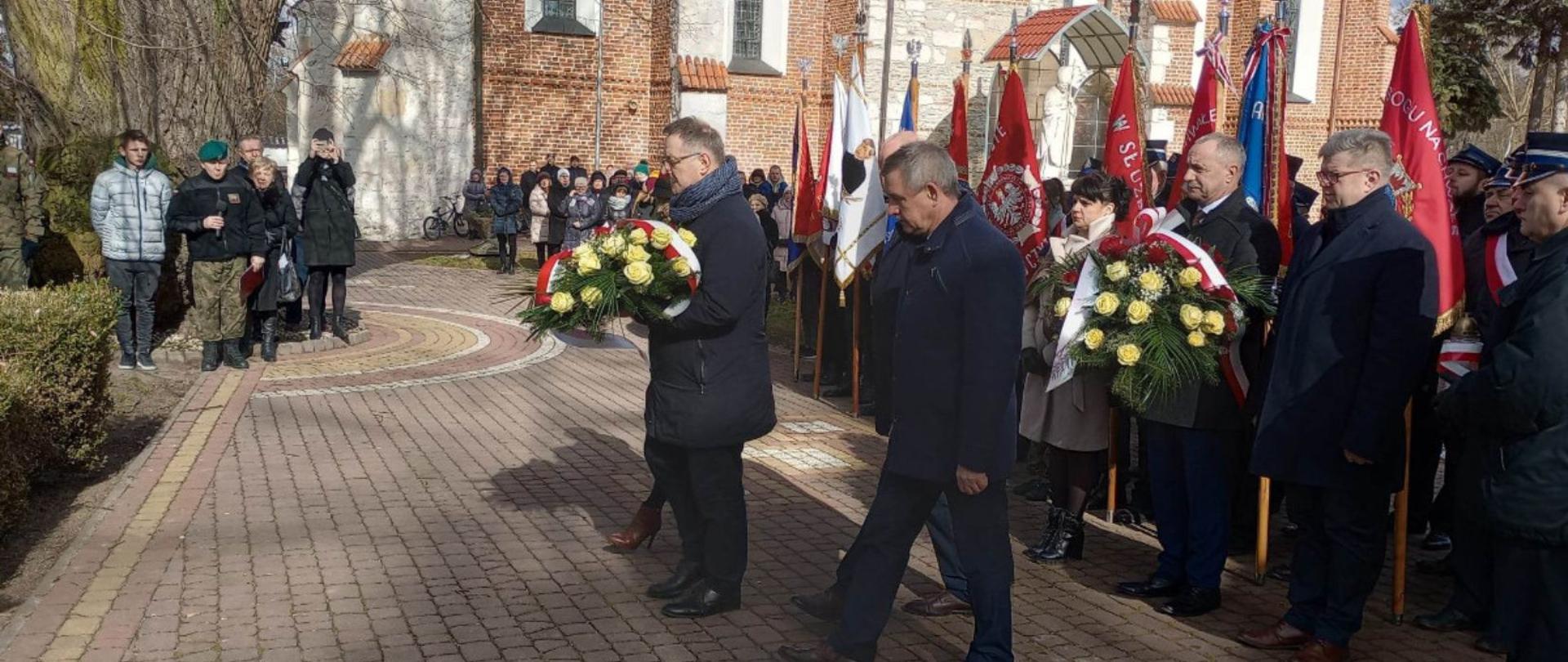 Przedstawiciele Powiatu Lipskiego składają wiązankę kwiatów przed pomnikiem.