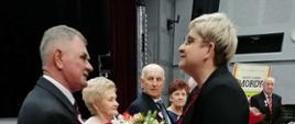 Kwiaty wręcza sekretarz Miasta i Gminy Mordy Monika Nasiłowska - Osik