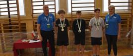 Pamiątkowe zdjęcie z dekoracji chłopców z rocznika 2007-2008, organizatorzy i trójka nastolatków pozuje do wspólnego zdjęcia