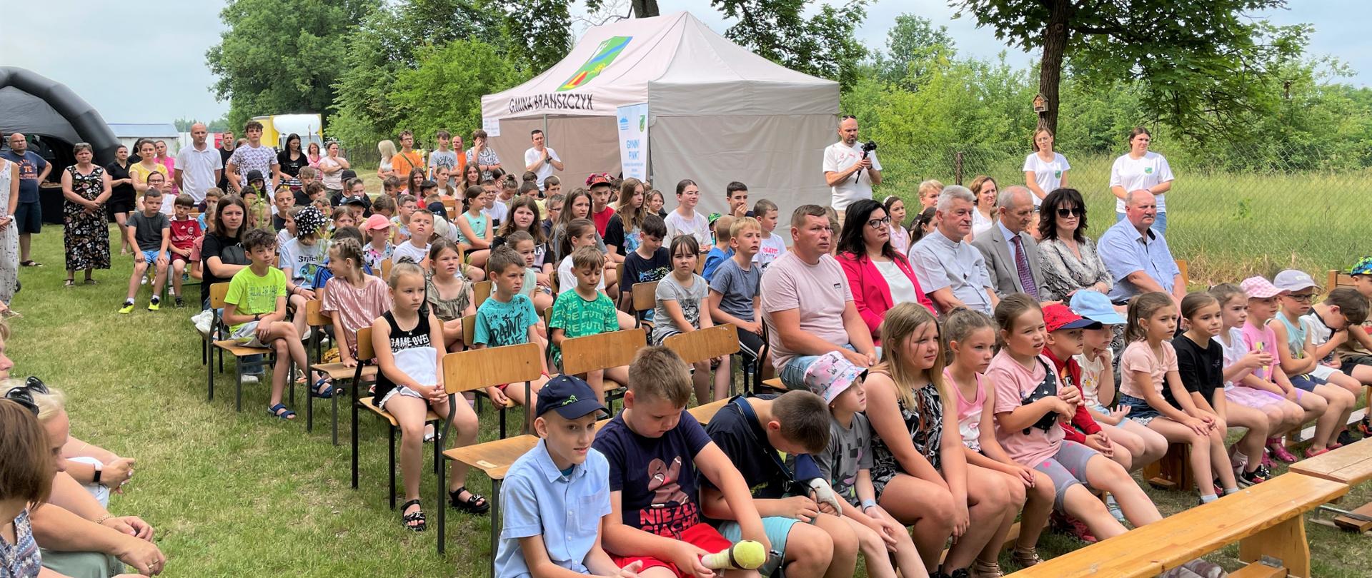 Uczestnicy pikniku siedzący na dworze.