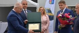 Starosta Hajnowski i Zastępca Burmistrza Miasta Hajnówka wręczają pamiątkowy grawerton