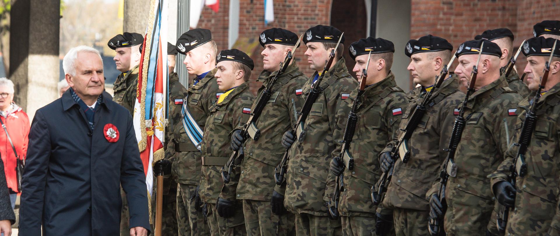 dwóch mężczyzn idzie przed żołnierzami