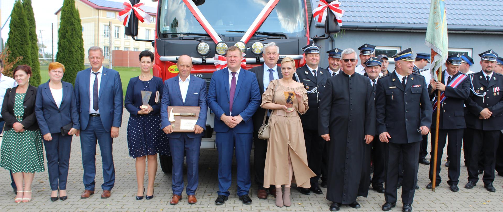 Starosta bielski Sławomir Jerzy Snarski wraz z pozostałymi uczestnikami uroczystości przy nowym samochodzie OSP Topczewo
