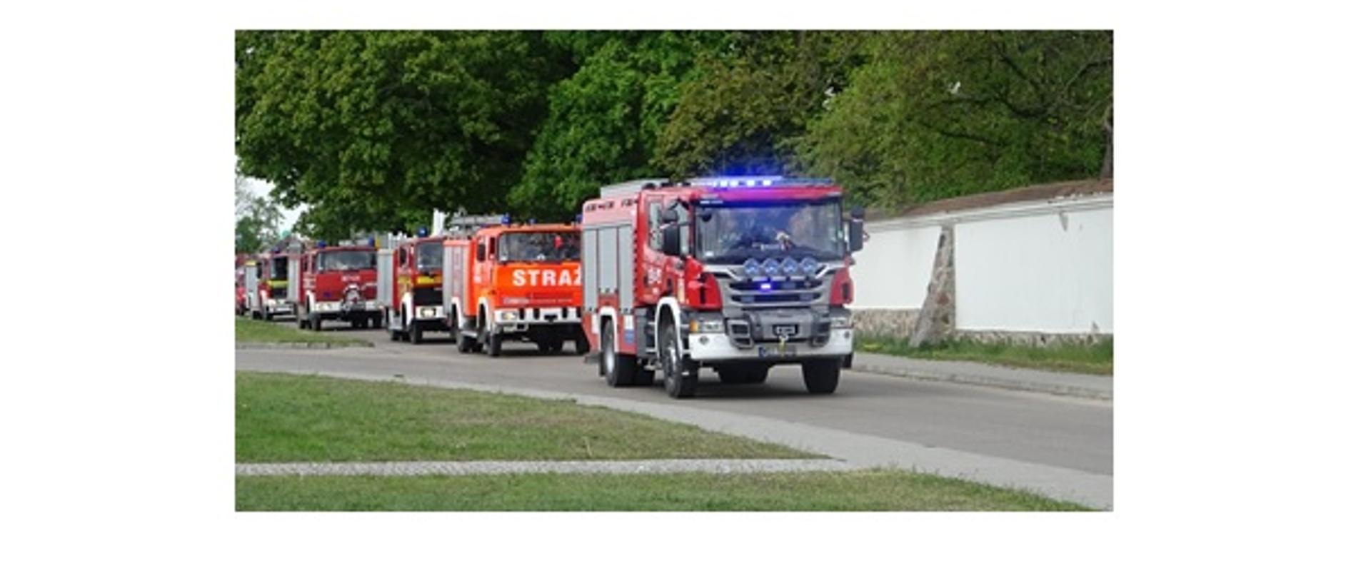 kolumna bojowych wozów strażackich. W tle park.