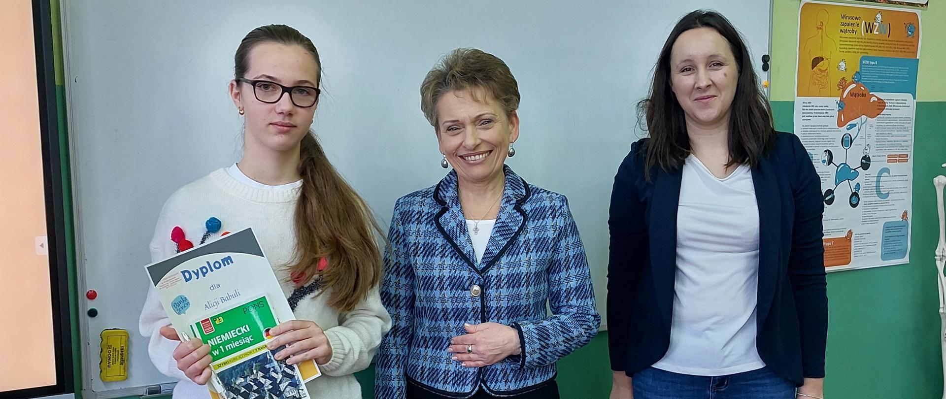 Uczennica nagrodzona w konkursie języka niemieckiego wraz z Dyrektorem szkoły i nauczycielką 