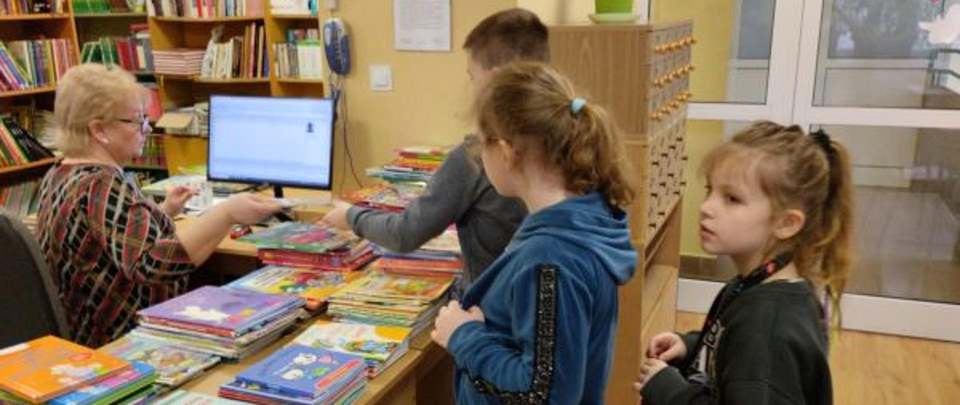 Uczniowie klas pierwszych wypożyczają książki