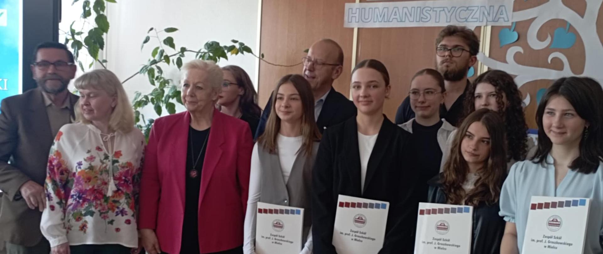 Zdjęcie przedstawia nagrodzonych w konkursie uczniów wraz z jurorami konkursu.