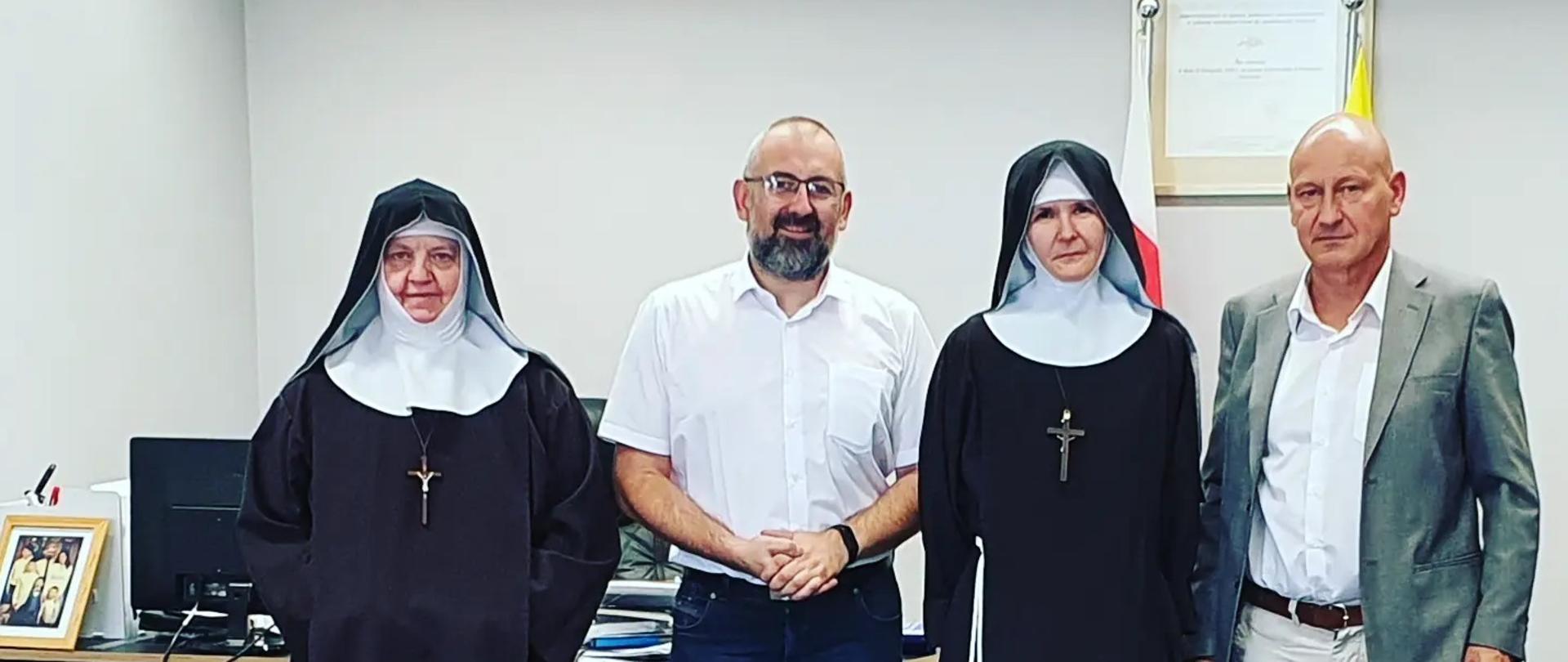 Zdjęcie przedstawia Siostry Klaryski Kapucynki wizytujące w gabinecie Starosty Przasnyskiego po podpisaniu umowy na remont zespołu klasztornego w Przasnyszu. Od lewej: Siostra Daria Opatka Klasztoru, Starosta Krzysztof Bieńkowski, Siostra Daria, Dyrektor Wydziału Budownictwa i Zarządzania Kryzysowego Jarosław Włodarczyk.