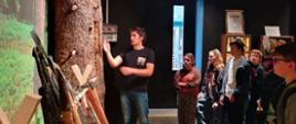 Grupa uczniów ogląda eksponaty w Muzeum Kultury Bartniczej.