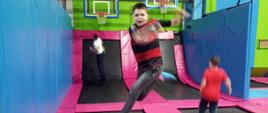 Uczeń wyskakuje w górę odbijając się na trampolinie