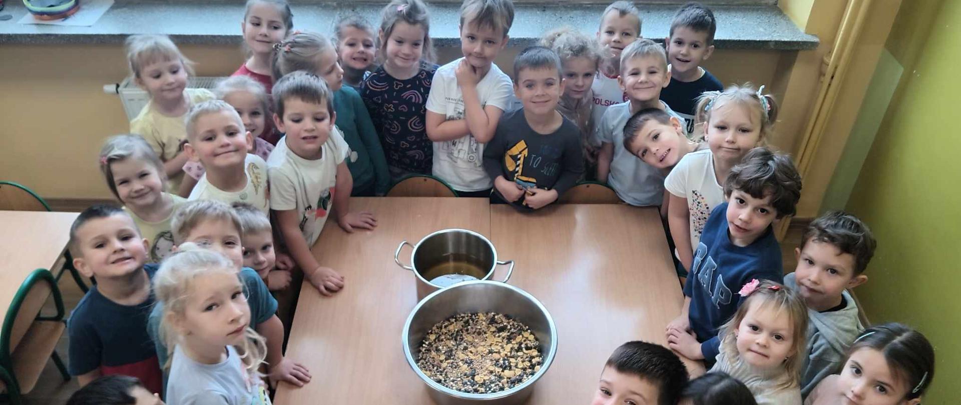 Dzieci wspólnie wykonują pokarm dla ptaków 