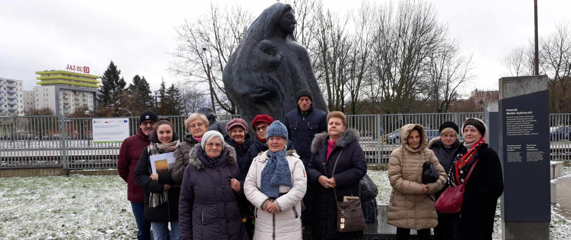 Członkowie klubu senior+ przed pomnikiem matki sybiraczki