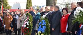 KLub Senior +, Barbara Soszyńska Przedstawiciel GOK, Przewodniczący Rady Gminy Marian Mazurek, Ks. Piotr Chodźko, Wójt Iwona Księżopolska, Delegaci z Ukrainy przed pomnikiem