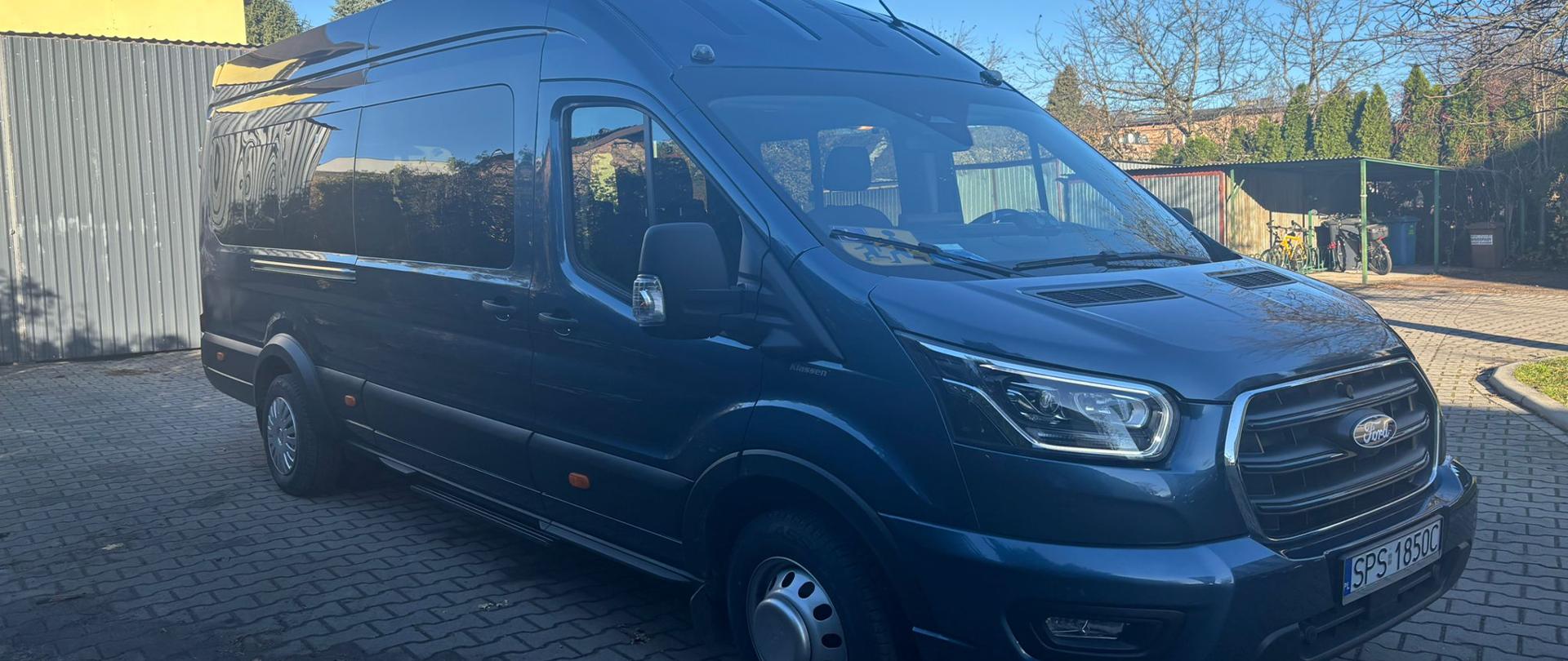 Ciemny bus stoi na placu parkingowym z kostki brukowej