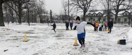 Zabawy na śniegu - dzieci na korcie pokonują tor przeszkód