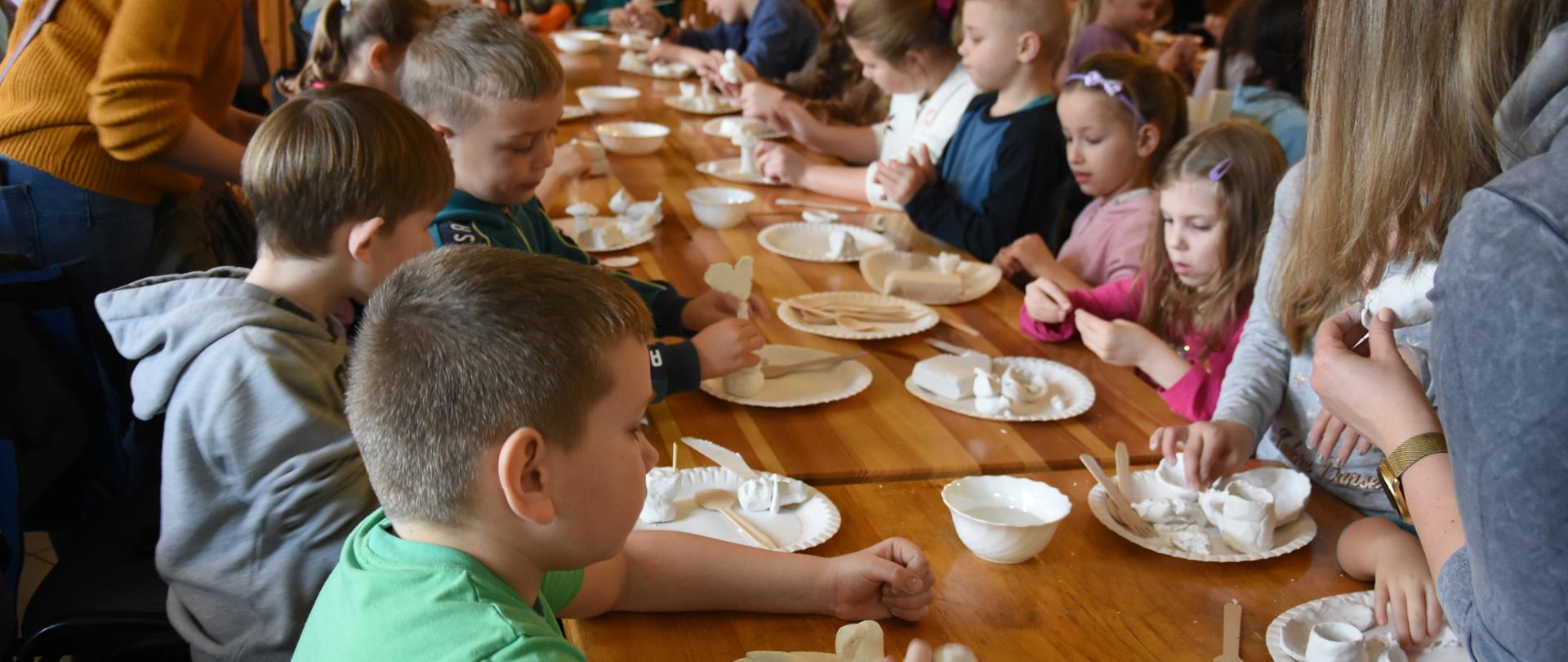 Pierwszy dzień „Ferii z wyobraźnią” -dzieci rzeźbiące w glinie