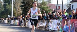 Kamil Jastrzębski na trasie biegu. Po prawej stronie widać licznie zgromadzoną publiczność