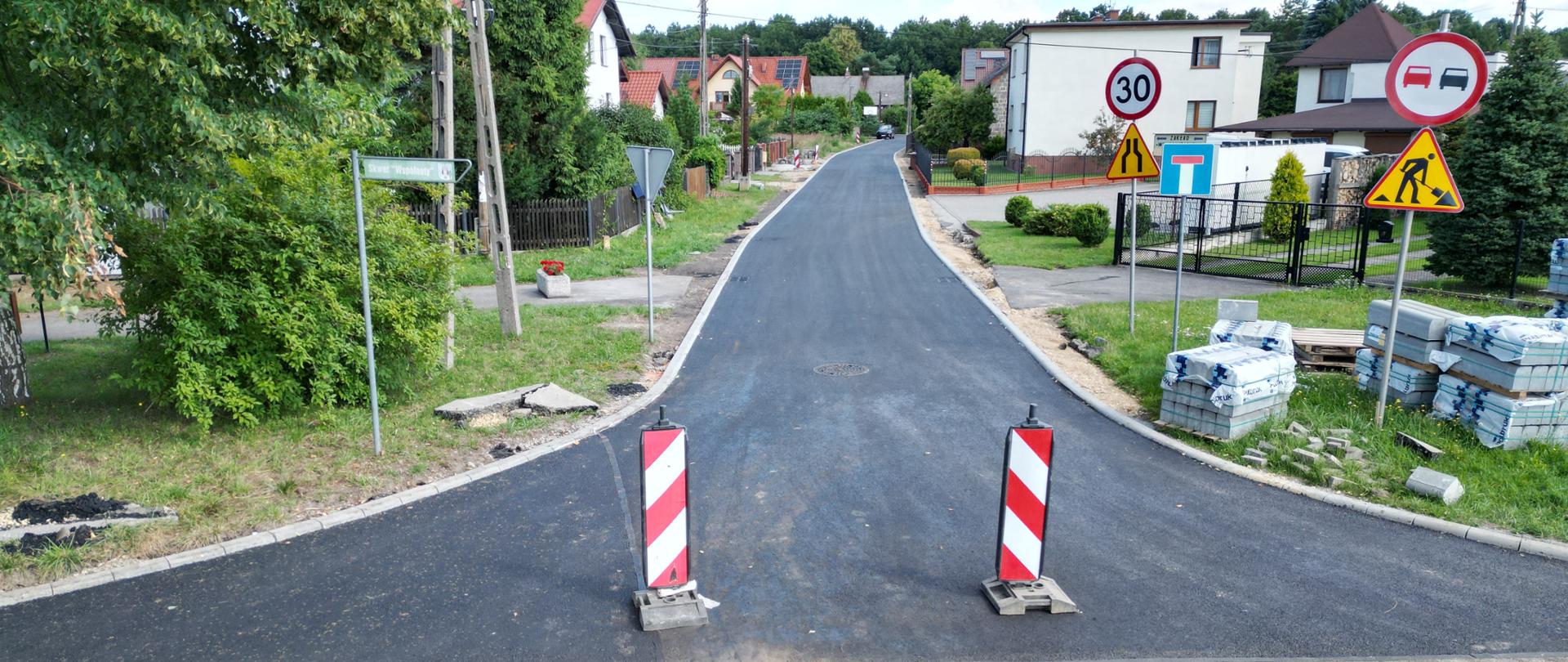 Nowy asfalt położony na drodze wśród domków jednorodzinnych