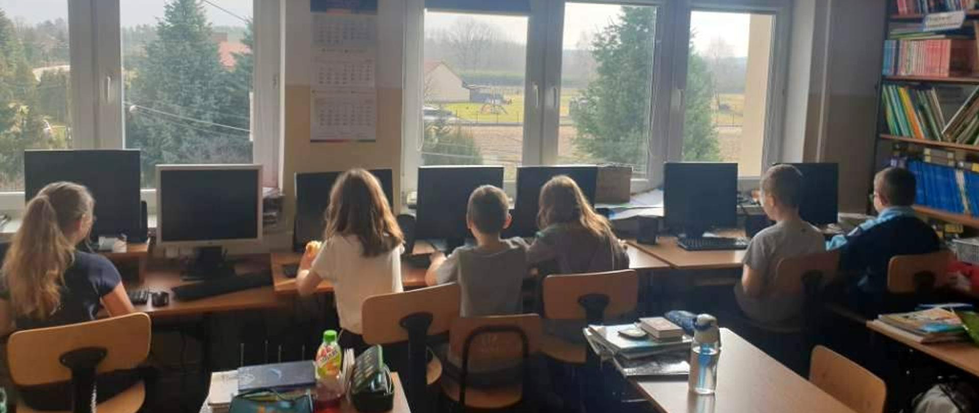 dzieci siedzące przy komputerach