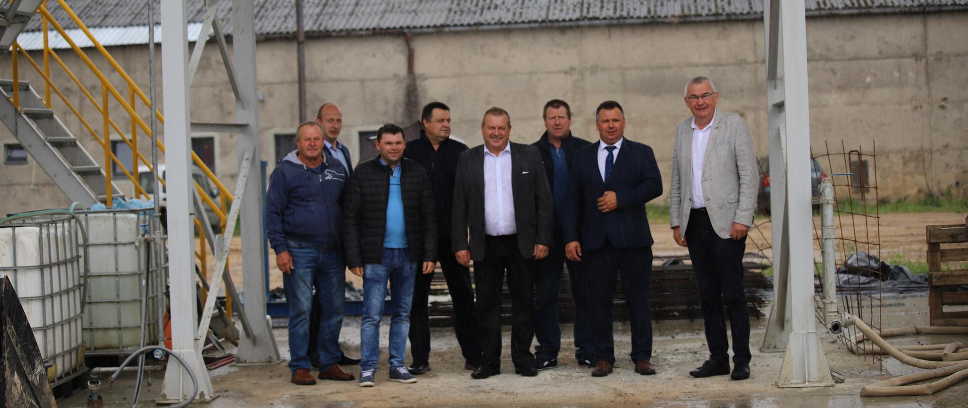 Ośmiu mężczyzn na tle szarego budynku