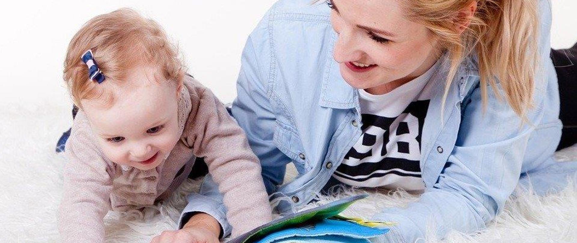 fotografia przedstawia mamę z dzieckiem podczas czytania książeczki 