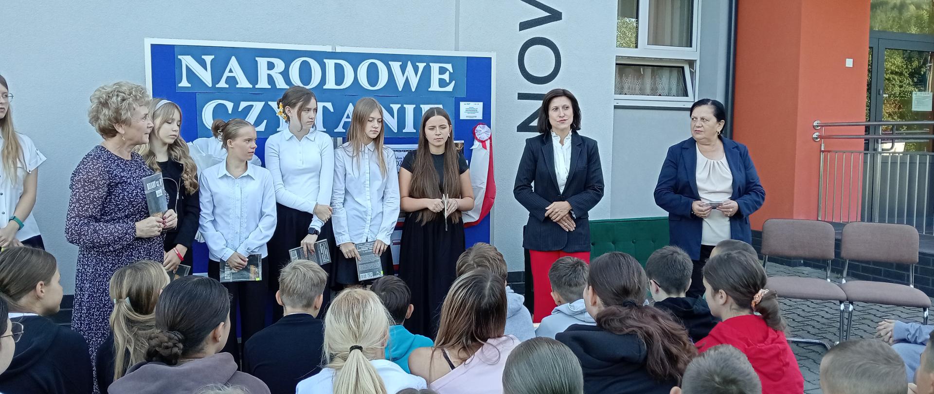 Pani wicedyrektor szkoły przemawia do zgromadzonych uczniów podczas akcji "Narodowe Czytanie"