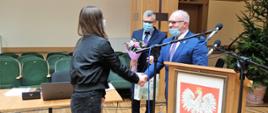 Starosta Hajnowski składa gratulacje, Przewodniczący Rady trzyma kwiaty i nagrodę