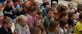 Dzieci oglądają sztukę teatralną z udziałem aktorów