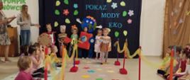 Dzieci ubrane w przygotowane przebrania z recyklingu, idą po "wybiegu" - kolorowym dywanie