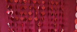 Kilkoro dzieci stoi na tle walentynkowym trzymając balon z napisem "love"