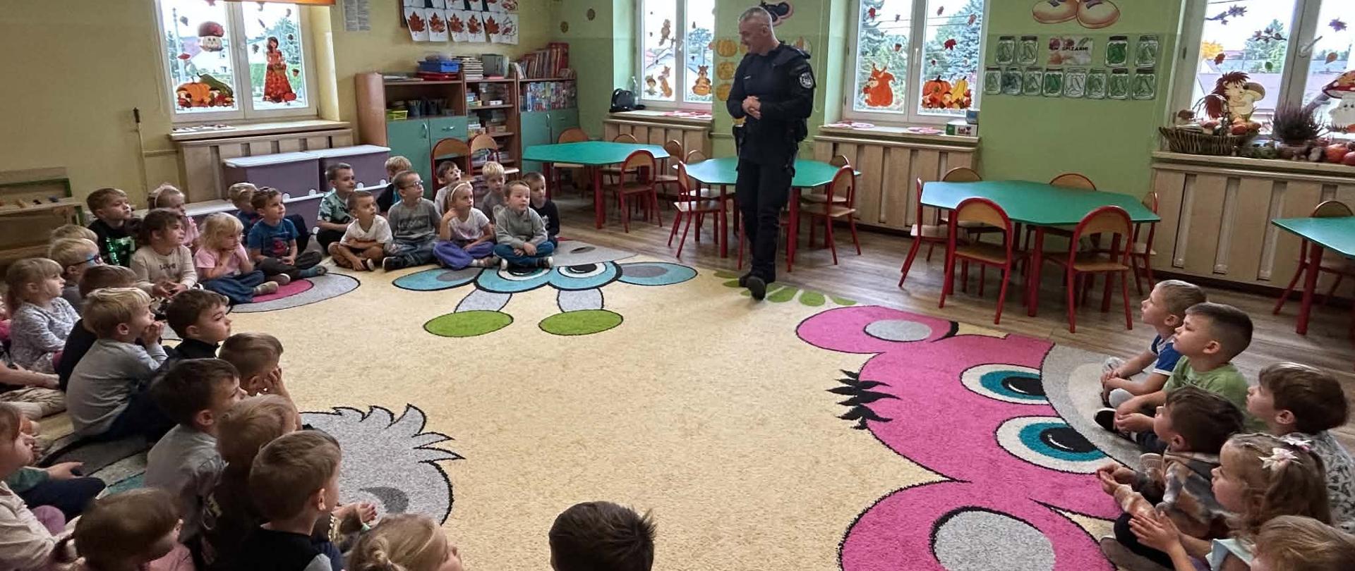 Grupa dzieci podczas spotkania z dzielnicowym