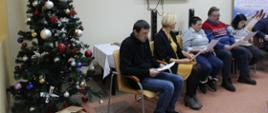 Koncert kolęd w wykonaniu uczestników Środowiskowego Domu Samopomocy, obok artystów ubrana choinka