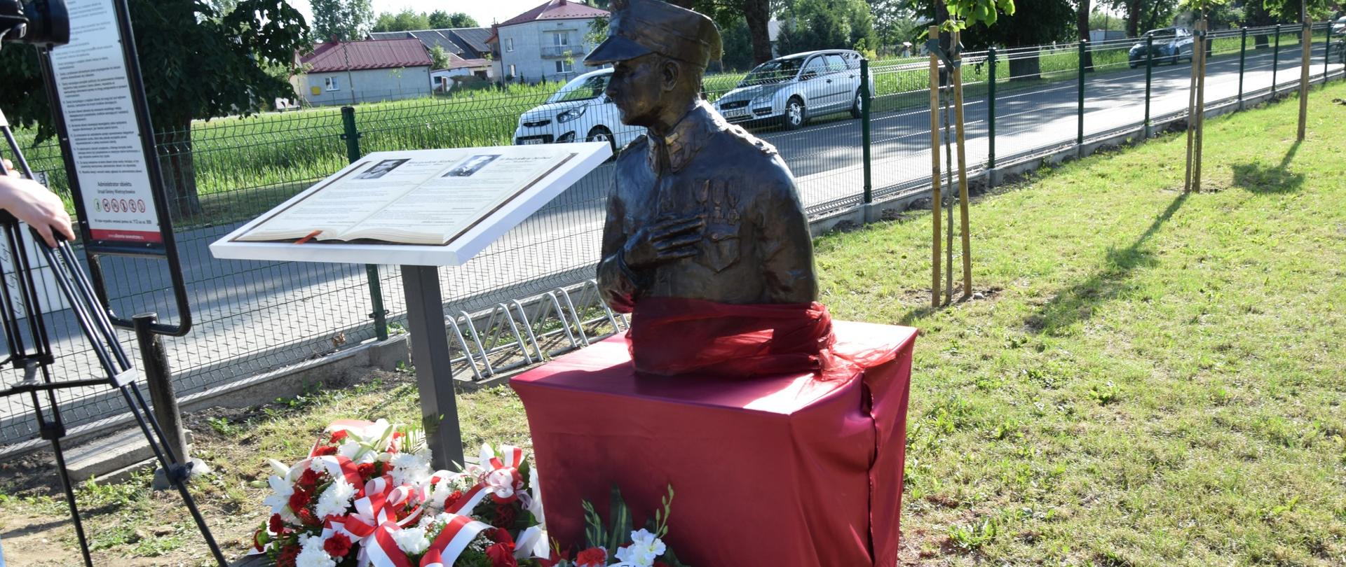 zdjęcie przedstawia pamiątkową tablicę oraz pomnik Płk. Władysława Kabata