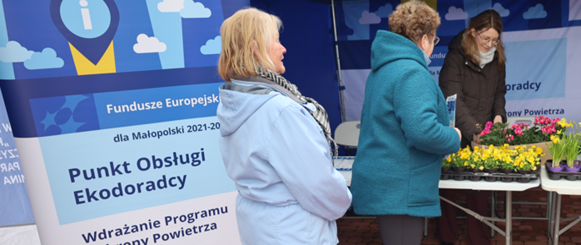 Mieszkanki odwiedzają punkt obsługi Ekodoradcy i zapoznają się z informacjami o ochronie powietrza