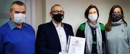 Grafika przedstawia zdjęcie wykonane podczas podpisania aktu notarialnego z firmą z branży lotniczej. 