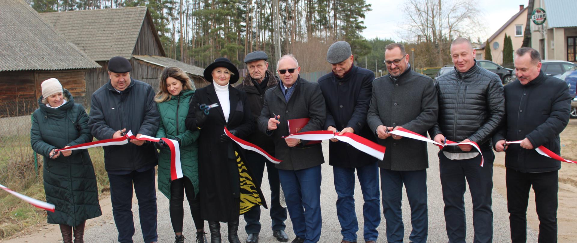Uroczyste otwarcie drogi - uczestnicy przecinają wstęgę