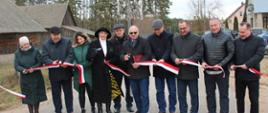 Uroczyste otwarcie drogi - uczestnicy przecinają wstęgę