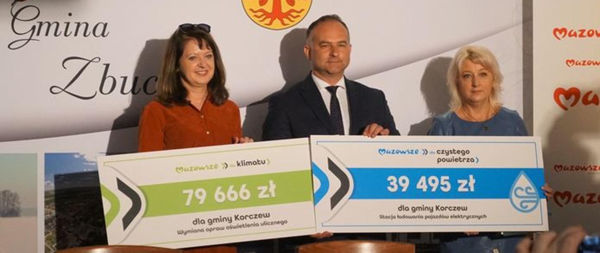 Ewa Orzełowska, Sławomir Wasilczuk, Marzanna Kałan trzymają symboliczne czeki na nowe inwestycje.
