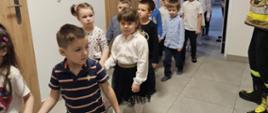 Dzieci w trakcie ewakuacji są wyprowadzane z sali